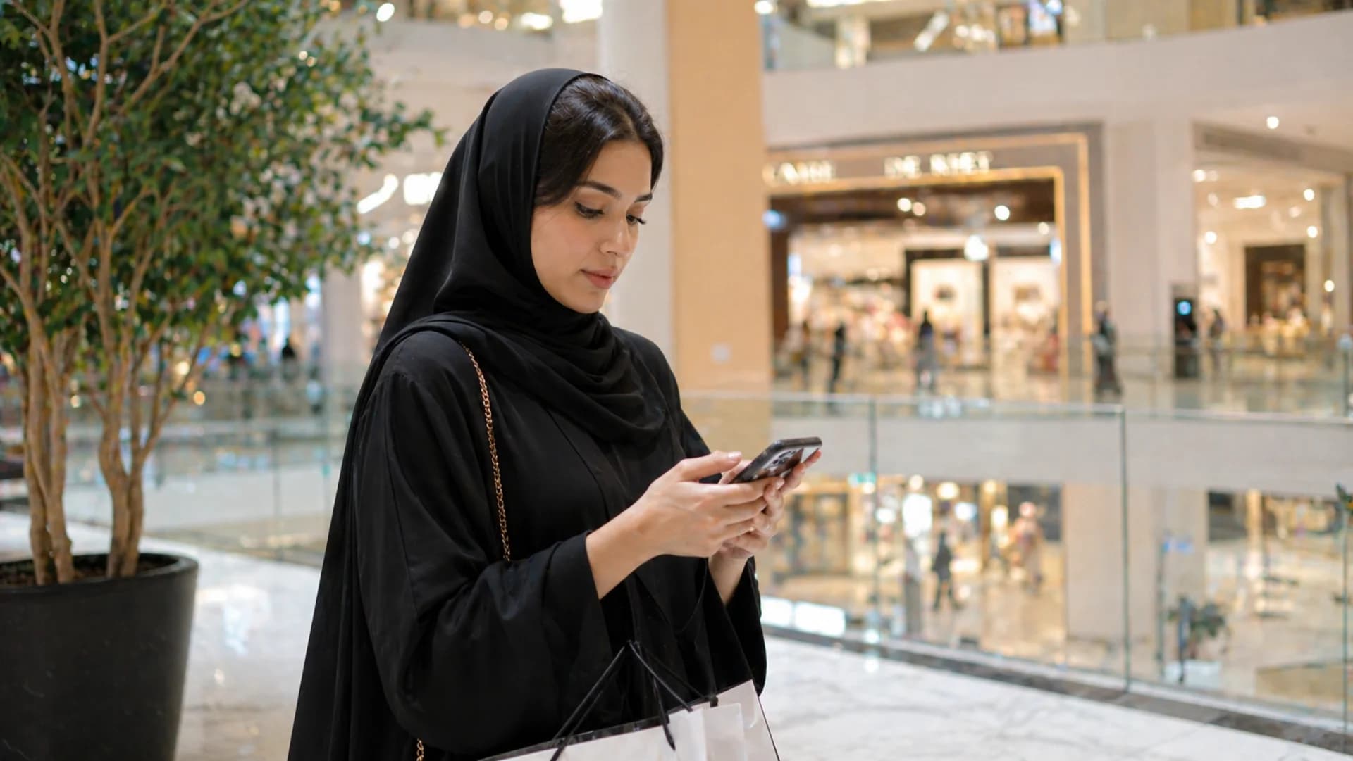 Tamara BNPL integration in KSA — young Saudi woman shopper using Tamara Pay-in-3 on phone at Riyadh mall